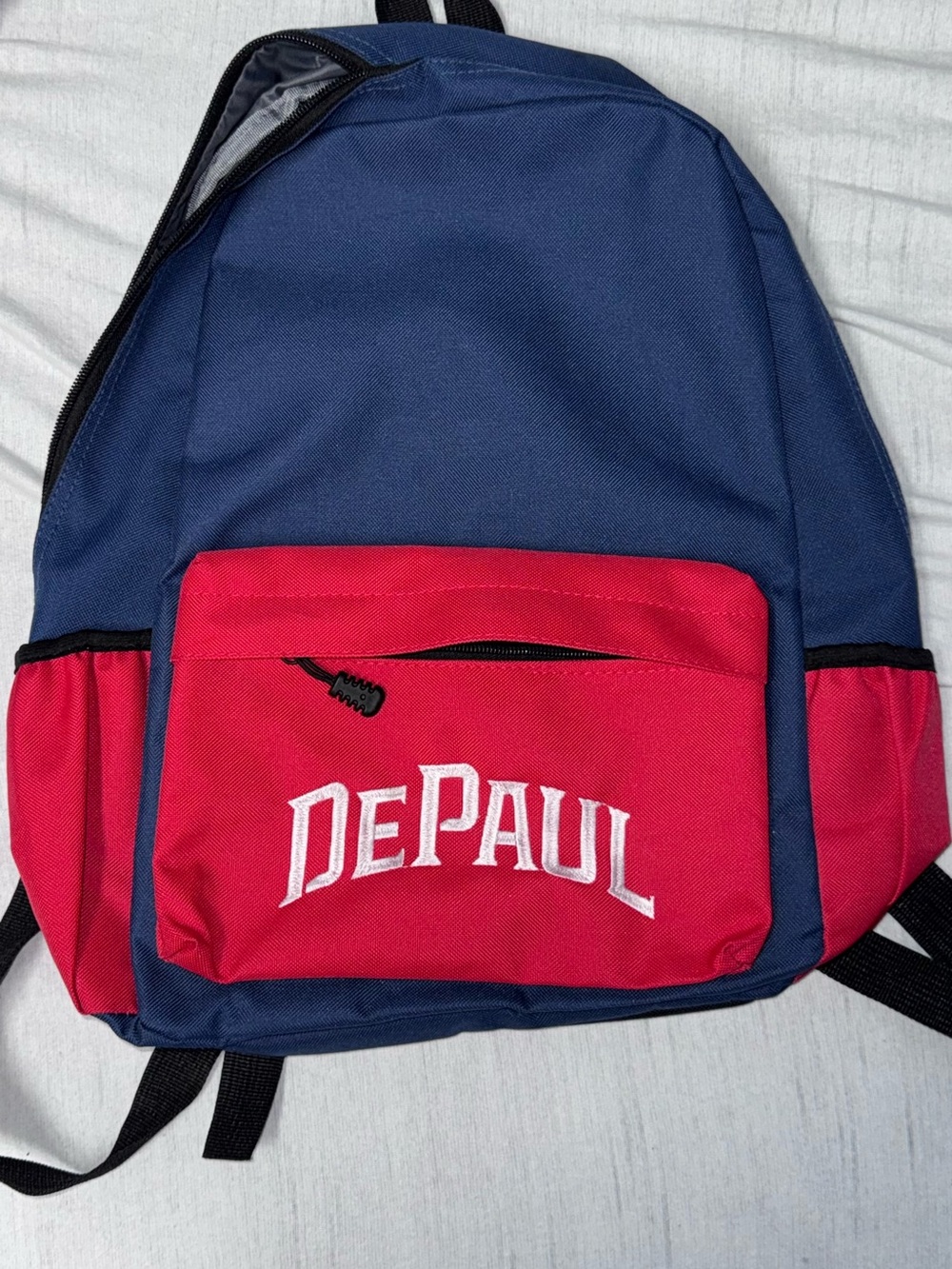 DePaul University navy blue and red backpack with white 'DEPAUL’ embroidered in